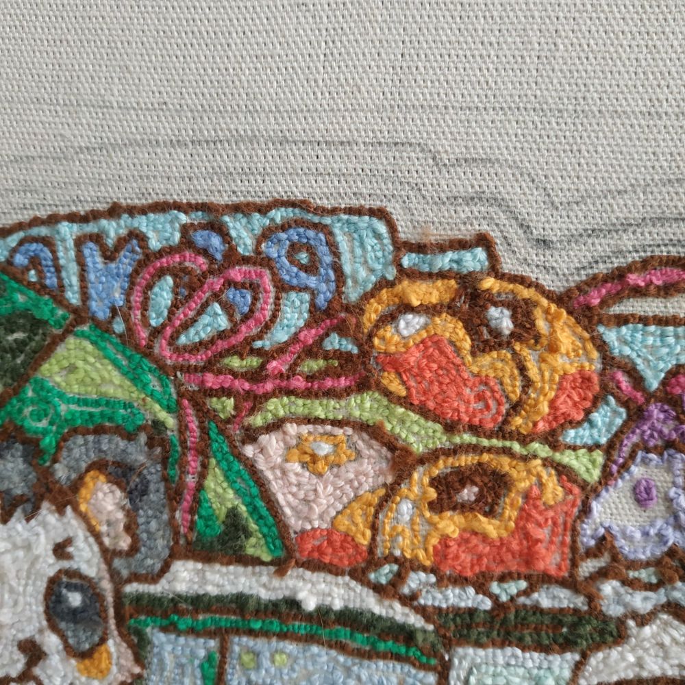 Foto com zoom de detalhe da parte dos tomates, feitos em 3 tons diferentes de laranja, pêssego e vermelho. A faixa azul escrito "panda" também aparece logo atrás da uma parte da melancia e um laço rosa que a amarra.