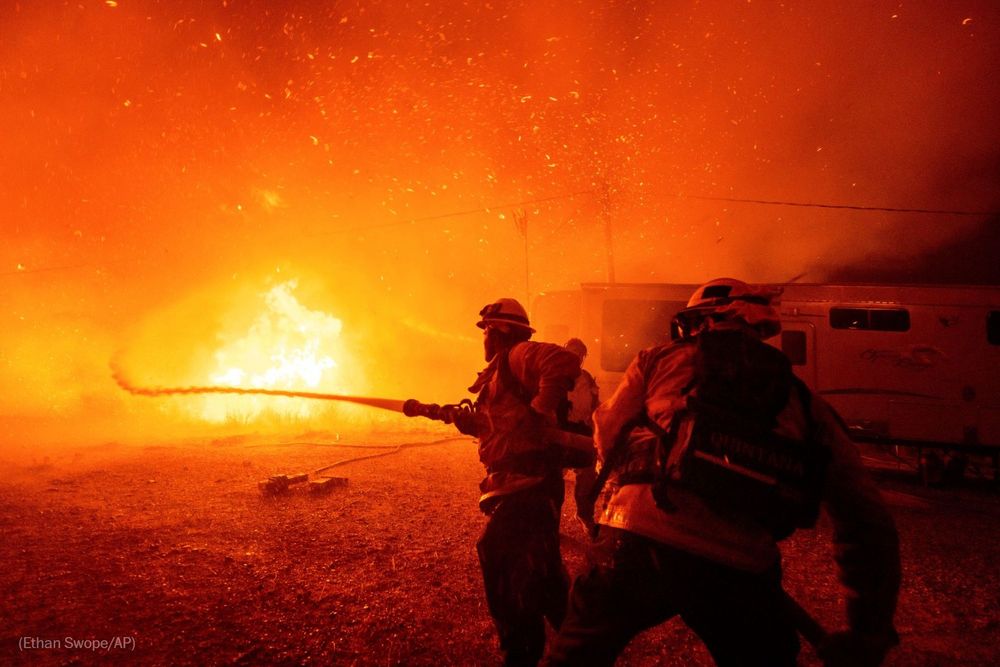Firefighters spray water on the Hughes Fire in Castaic, Calif. Photo by Ethan Swope for AP.