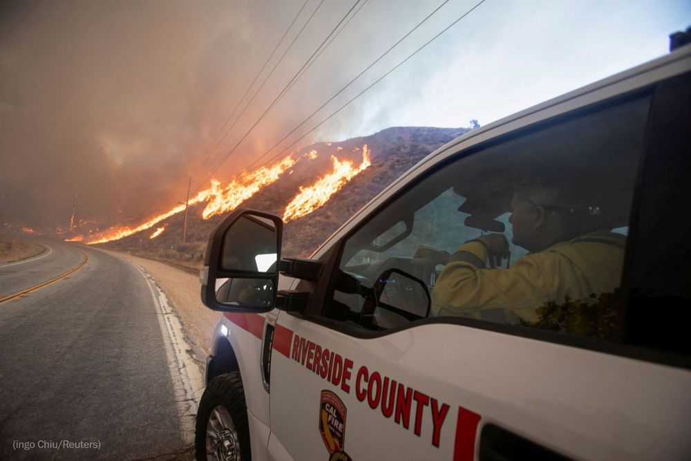 A firefighter looks on from his vehicle as the Hughes Fire burns near Castaic Lake. Photo by Ringo Chiu for Reuters.
