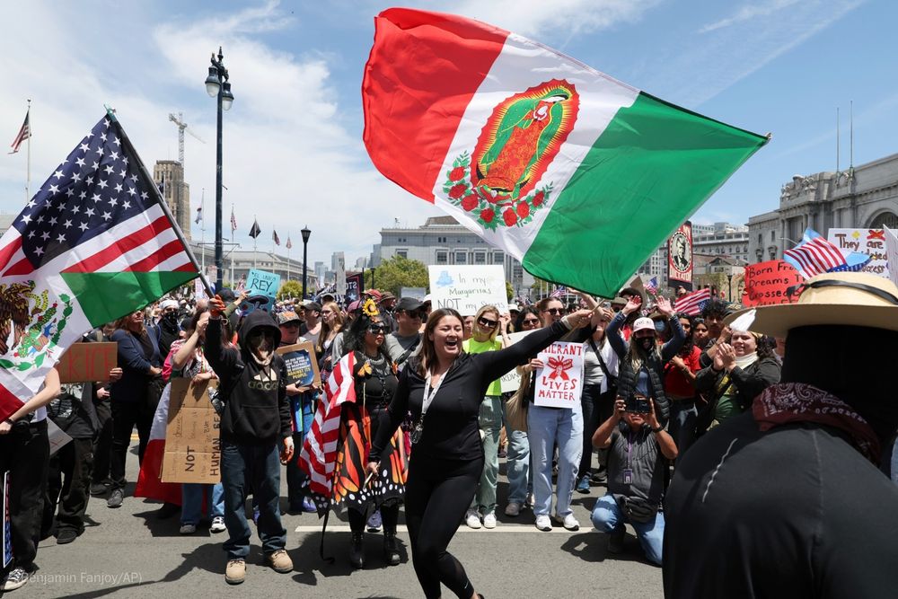 Protestors wave flags during a "No Kings" rally.

