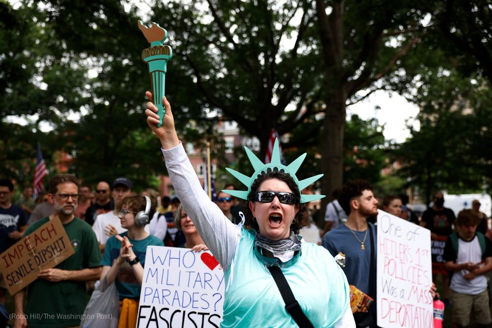 A protestor dressed as the Statue of Liberty at a "No Kings" rally.
