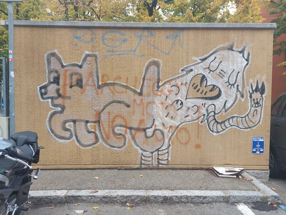 A large beige wall, with a large spray-painted outline of a dog and a white spray-painted ghost-looking thing.