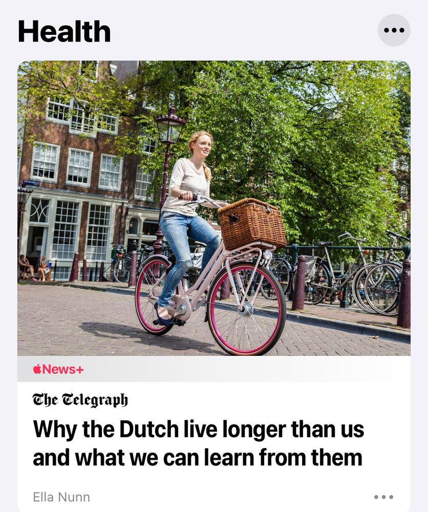 A picture of a lady pootling on her bike in a Dutch city.
The headline from The Telegraph states “Why the Dutch live longer than us and what we can learn from them”