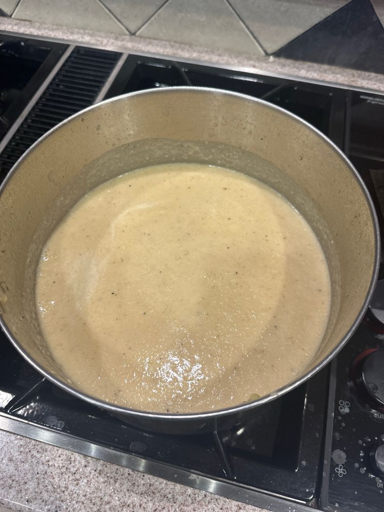 Big bubbling pot of creamy cauliflower soup.