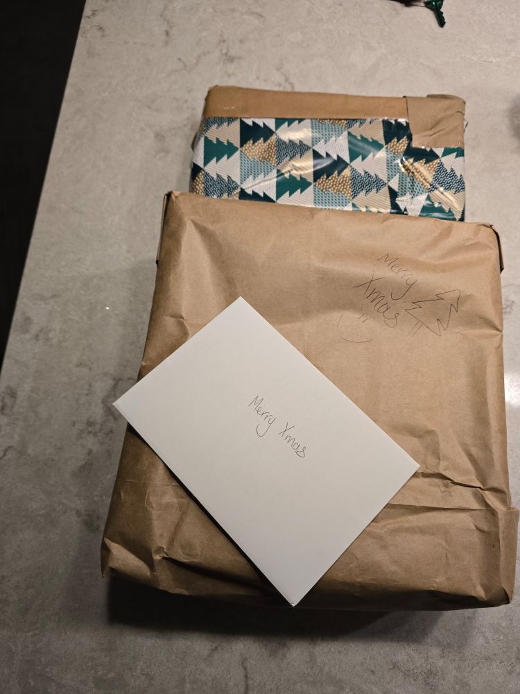 I have 2 wrapped gifts and a card with merry Xmas written on the card and merry Xmas on the parcel with a silmiley face and a hand drawn tree.  