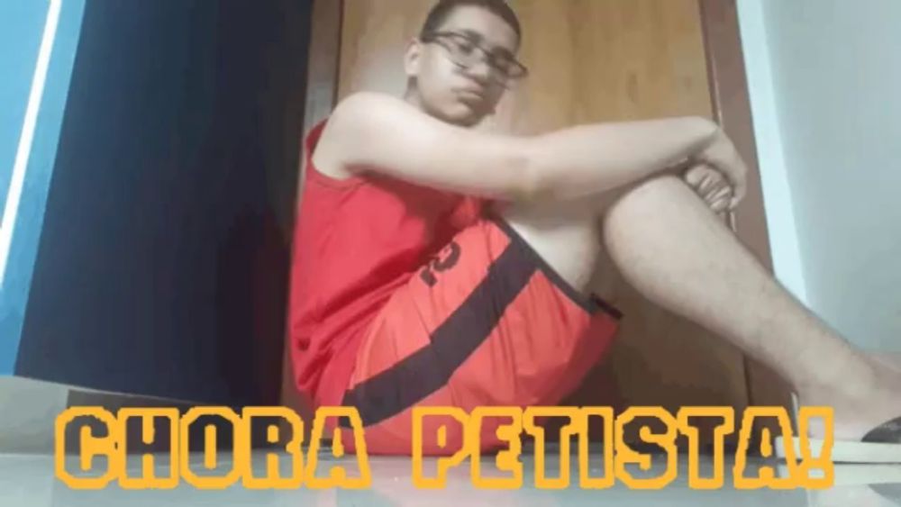 a man in red shorts sits on the floor with the words chora petista on the bottom