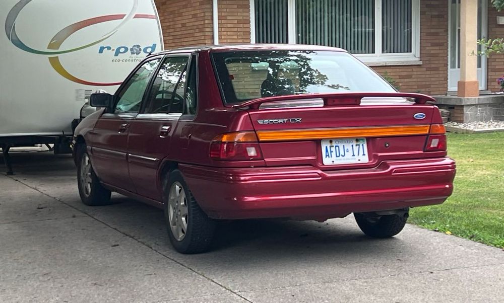 90’s Escort with spoiler! in driveway