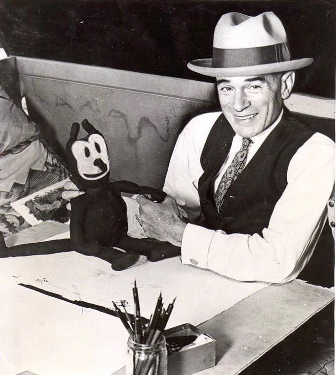 A photo of Herriman at his drawing table with a Krazy Kat doll.