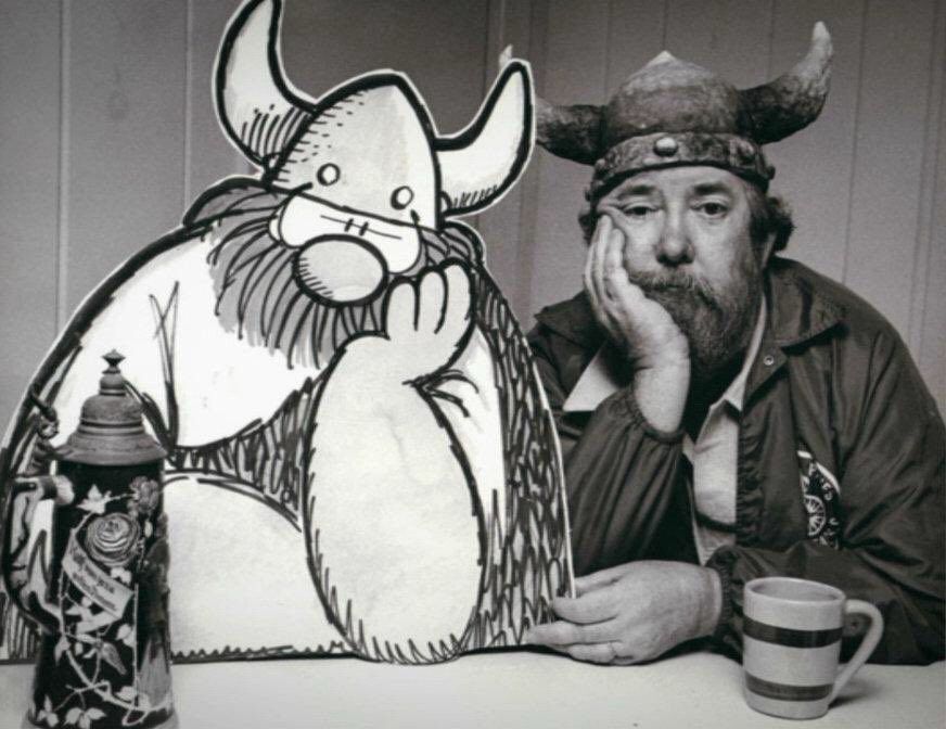 A photo of Hägar the Horrible and Browne sitting next to each other. Brown has a helmet like Hägar and a similar beard.