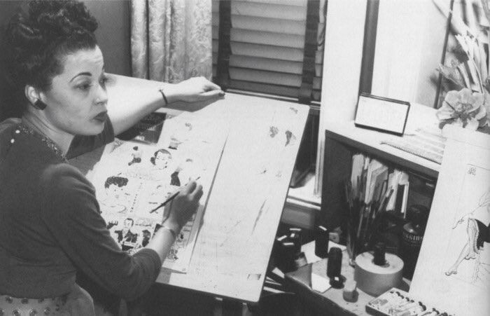 A photo of her at her drawing table.