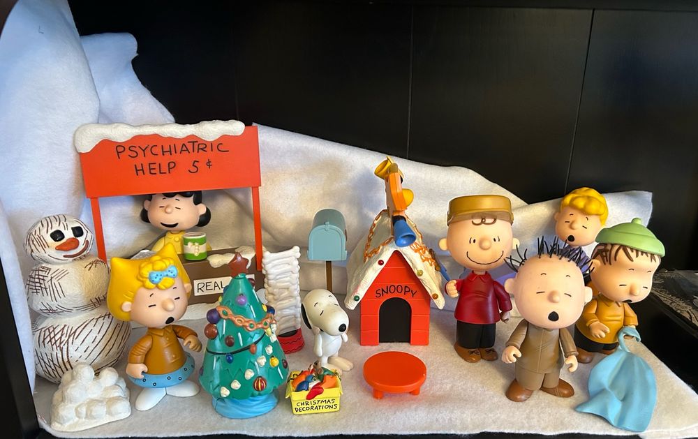 Peanuts Christmas figurines, including Charlie Brown, Linus, Lucy, Pigpen, Sally, Schroeder, and Snoopy