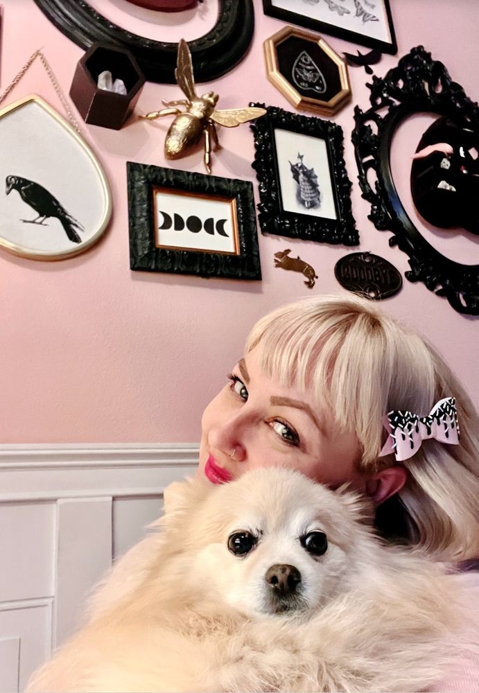 Photo of me in my living room, cuddling my fluffy white Pomeranian.