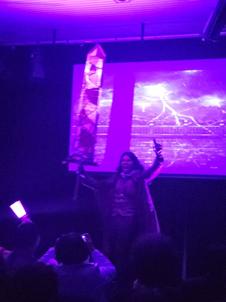 A blurry image of a Erlking Heathcliff cosplayer wielding his sword and yelling