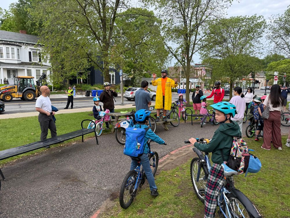 Nathan from Safe Routes to School stands on a picnic table addressing the bike bus crowd before our ride