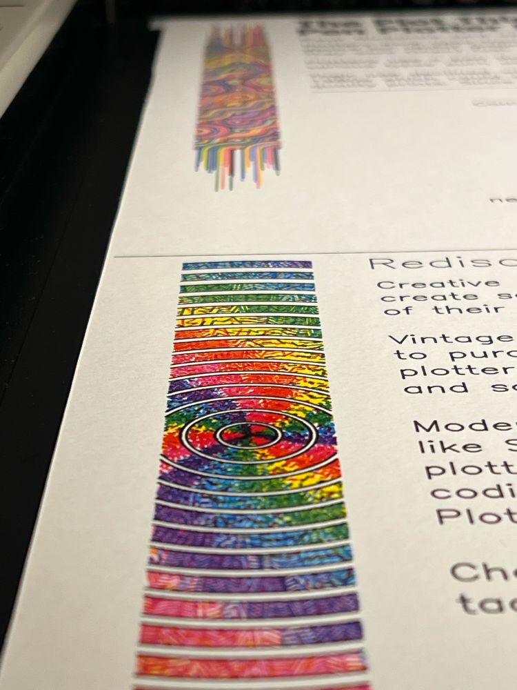 An oblique view of the poster showing some color splashes of pen plotter artwork. 