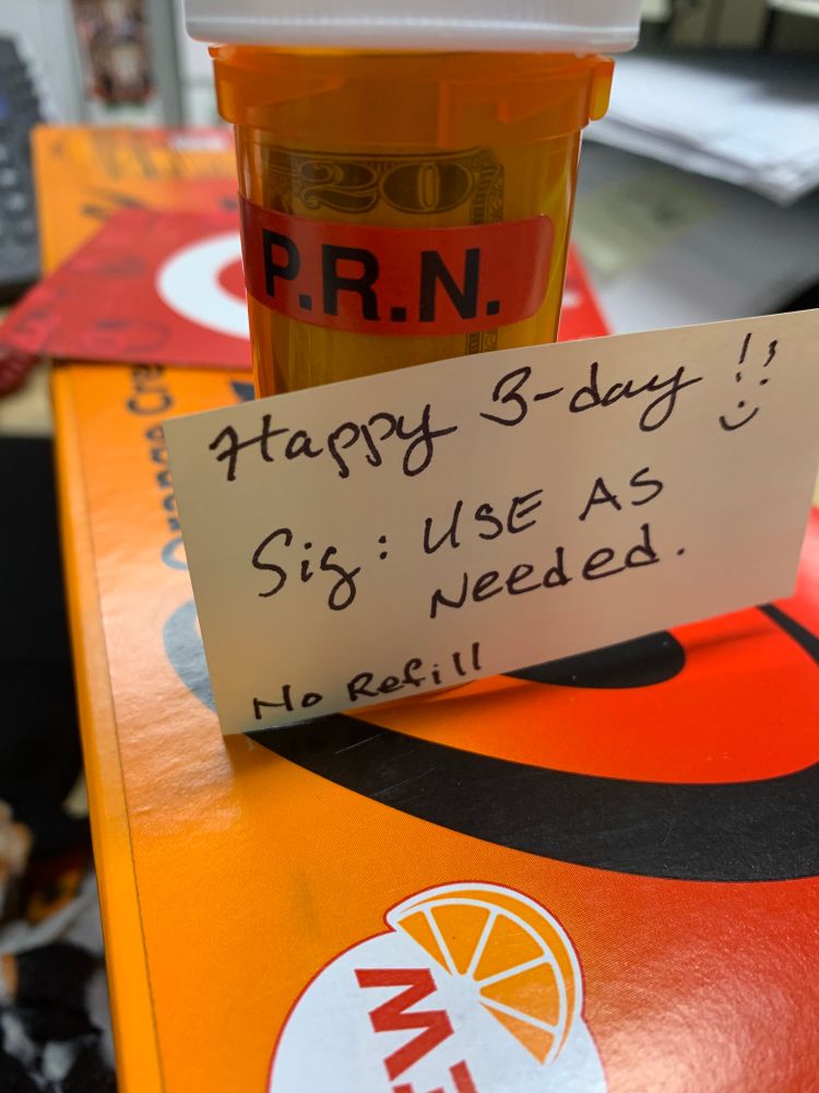 On top of orange cream Coke Zero is a target gift card and a pill vial with a PRN sticker on it. A note is on it the vial saying “happy B-day. Sig: use as needed. No refill” 