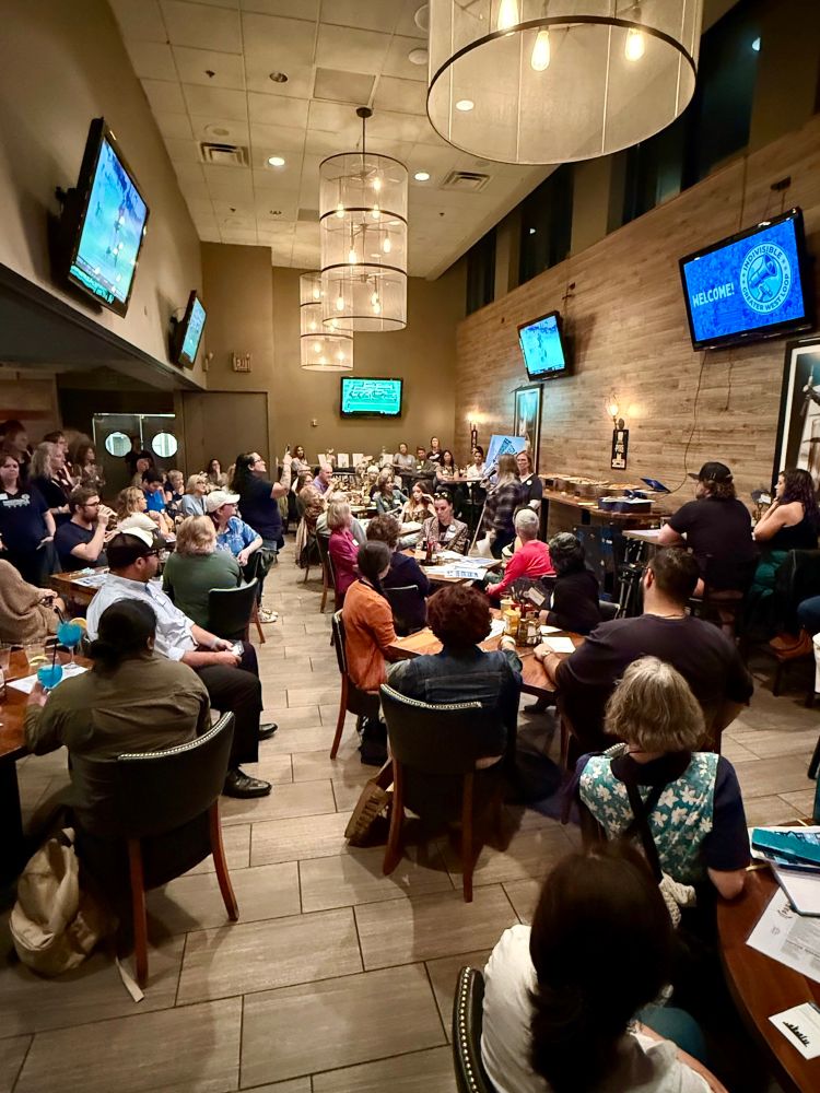 People in a room listening to a speaker 