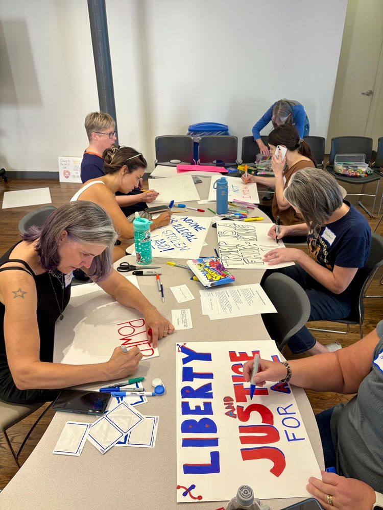 People working around a table on protest signs 