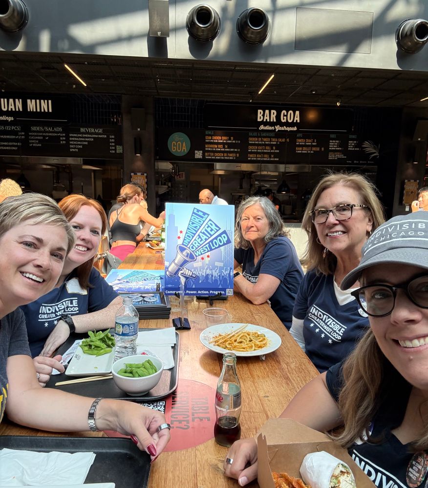 5 women around a table with food at a restaurant 