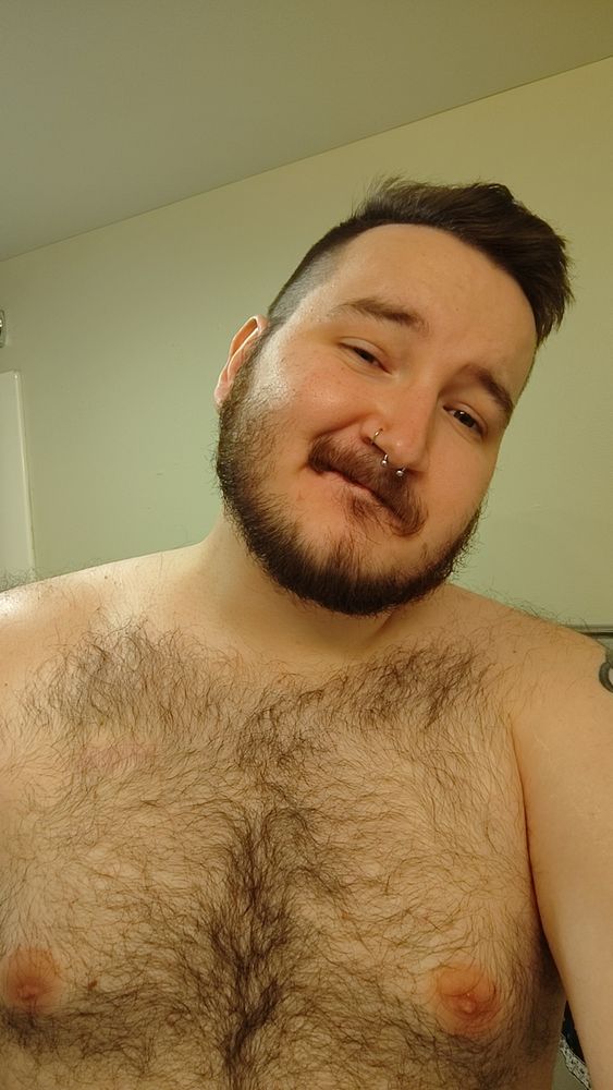 A picture of me, post-haircut. I am shirtless, brown hairs covering my chest and torso. 