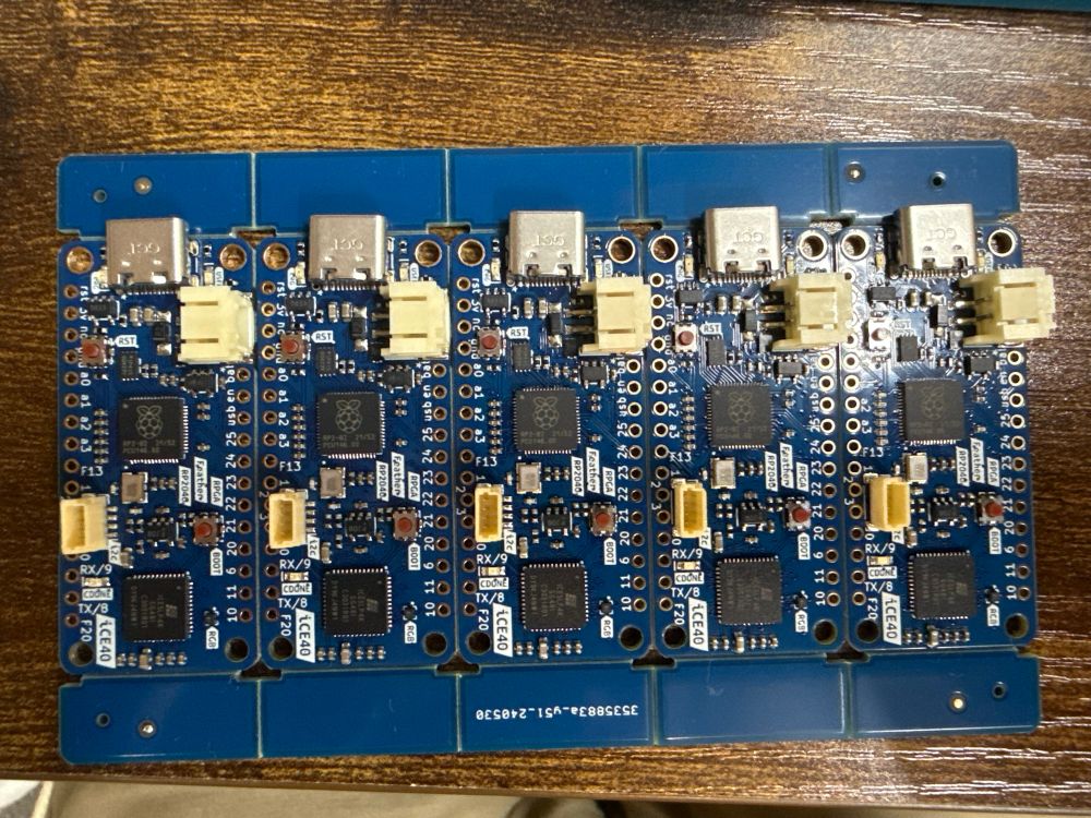 Fully assembled RPGA Feather mini panel. Blue PCB with RP2040 Microcontroller, an ICE40 FPGA, all in and Adafruit feather form factor.