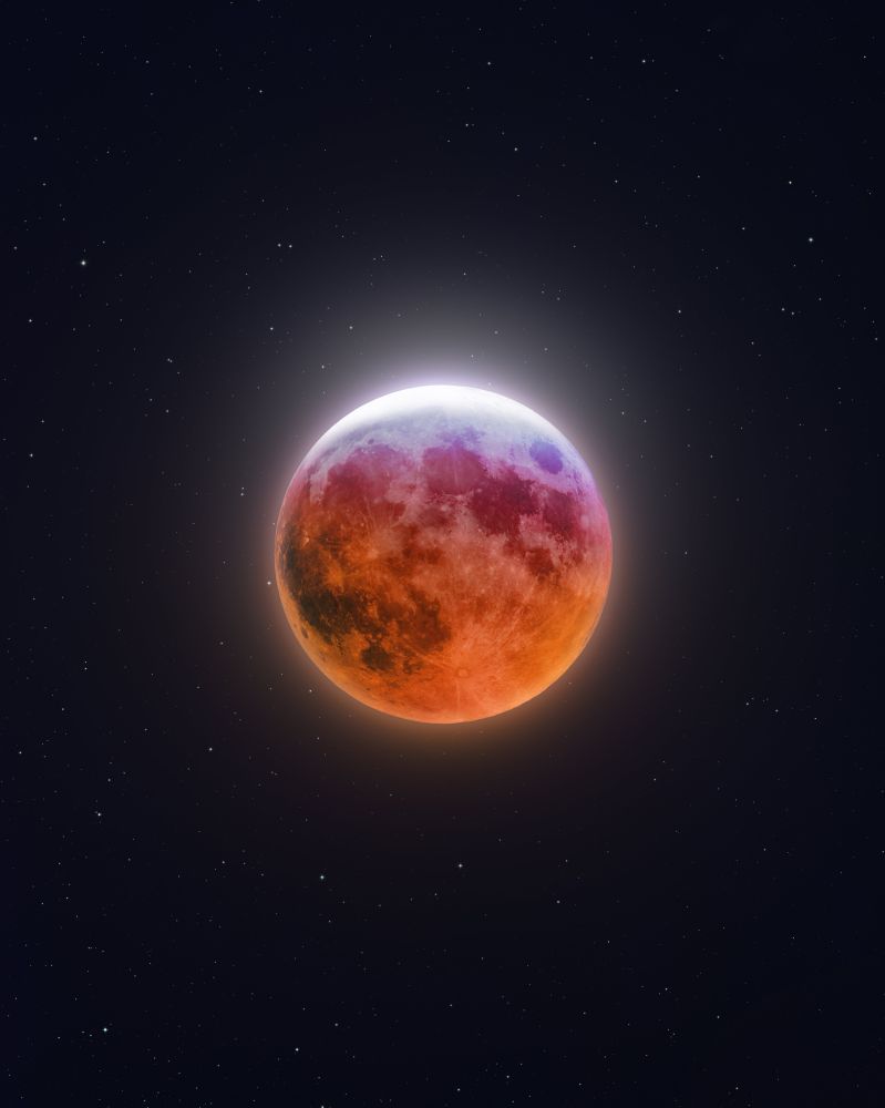 Photograph of the moon on the night of the blood moon. It’s bathed in colors of orange and pink.  Photo from @ajamesmccarthy on Twitter 