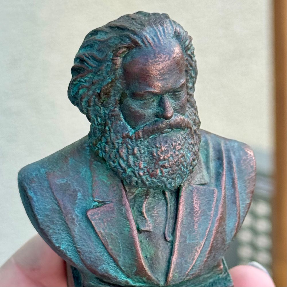 A 3D printed bust of Karl Marx painted to look like an old copper statue