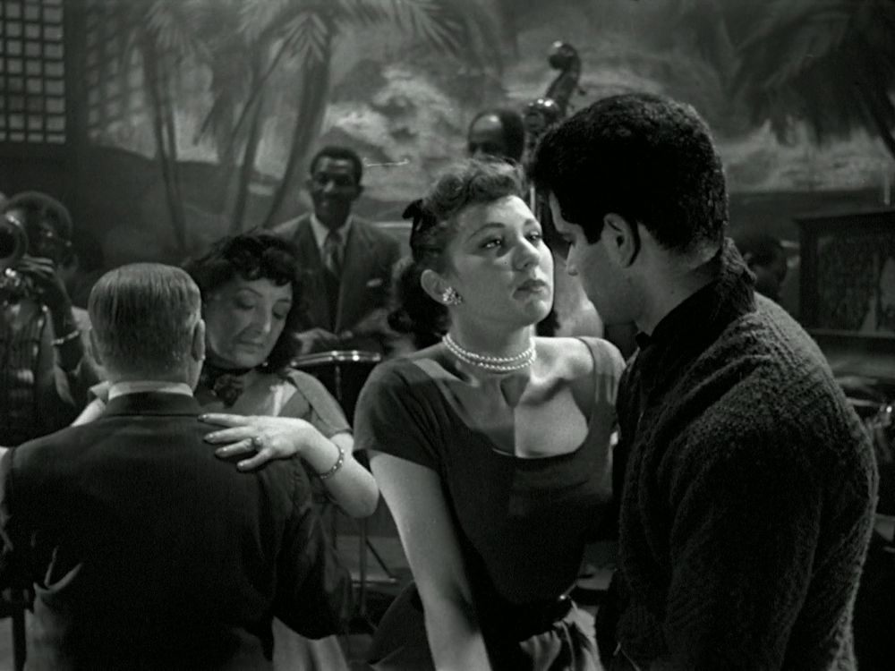 Two patrons dance, neither of whom conform with upper class white British standards.