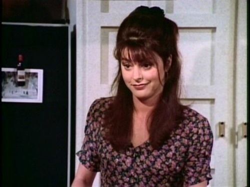 A still from the television show Fraiser showing a smiling Daphne in a kitchen
