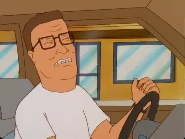 Still from the television show King of the Hill showing Hank sitting in his truck with a grimace and his eyes closed with one hand slightly raised, it kind of looks like he is rocking out