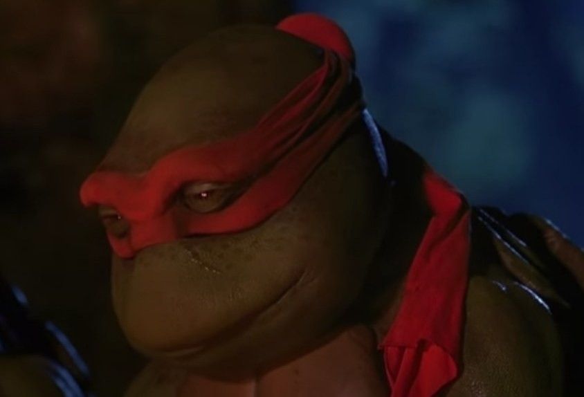 Still from the first teenage mutant ninja turtles showing one of the turtles looking dejected and sad