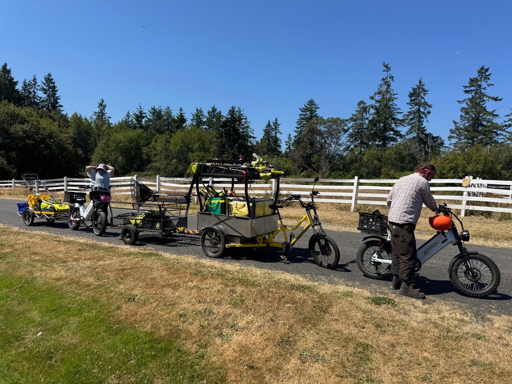 2 e-bikes, cargo with trailer, pastoral background with pnw trees