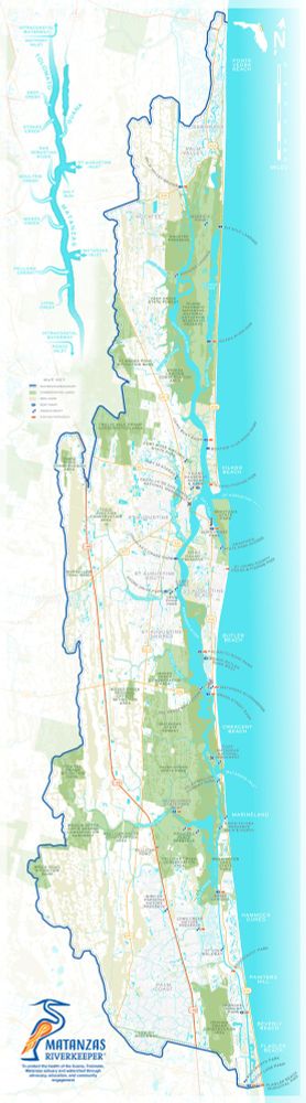 This map covers the Guana, Tolomato, Matanzas estuary and watershed around the city of St Augustine, on the east coast of Florida. It is a tall, narrow image with the ocean in light blue to the right and white land to the left. Conservation areas are shown in light green, while wetlands are a faded olive color. In the top left corner is a abstract water diagram showing the major rivers within the watershed and the tributaries that flow into them. A logo for the Matanzas Riverkeeper and a mission statement sits in the bottom left corner. The logo is the stylized outline of a great blue heron in blue and orange colors. 