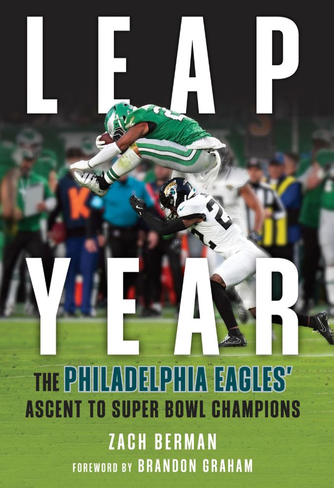Book cover of Leap Year: The Philadelphia Eagles' Ascent to Super Bowl Champions. By Zach Berman. Foreword by Brandon Graham. Cover design features a photo of Saquon Barkley leaping backwards over a defender while carrying the football.