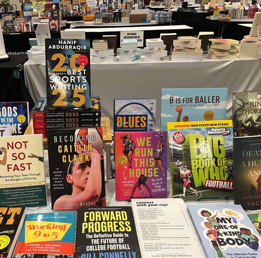 A variety of books are displayed on a table at the Heartland Fall Forum conference. They include The Year's Best Sports Writing 2025, edited by Hanif Abdurraqib; Becoming Caitlin Clark by Howard Megdal; We Run This House by AnnaSofia Dickens; The Franchise: St. Louis Blues by Jim Thomas; Forward Progress: The Definitive Guide to the Future of College Football by Bill Connelly; B Is for Baller by James Littlejohn and Matthew Shipley; and The Big Book of Who: Football by Sports Illustrated Kids.