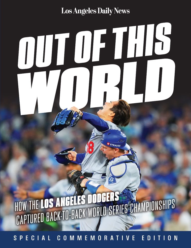 Cover of the Dodgers World Series commemorative book 'Out of This World: How the Los Angeles Dodgers Captured Back-to-Back World Series Championships' featuring a photo of Yoshinobu Yamamoto being lifted up by Will Smith after the final out of Game 7.
