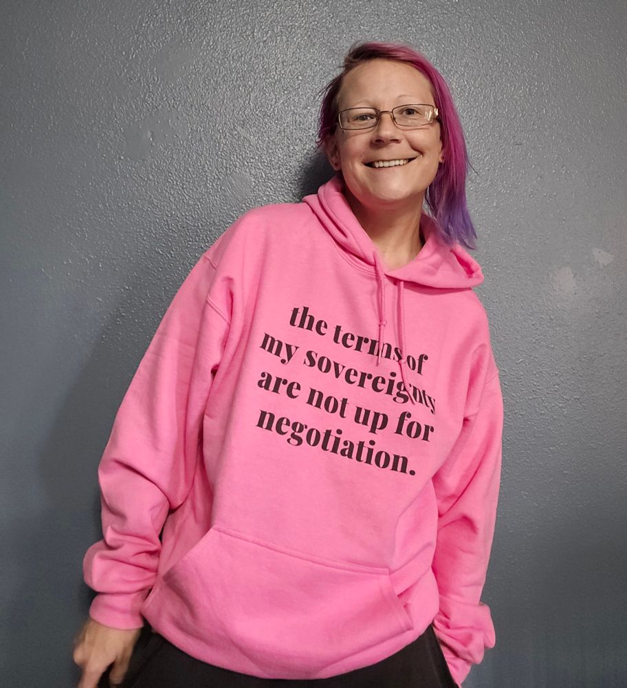 The focus for this picture is a pink hoodie with black writing that says, "The terms of my sovereignty are not up for negotiation." 