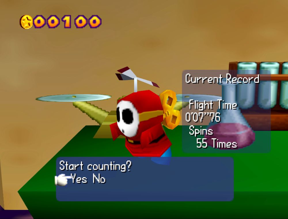 A screenshot from the game Mario Party showing a wind-up shy guy on a table. There is a text box showing the current record flight time of 0'06''76 and 55 spins. There is also a confirmation dialogue box asking if you would like to start counting.