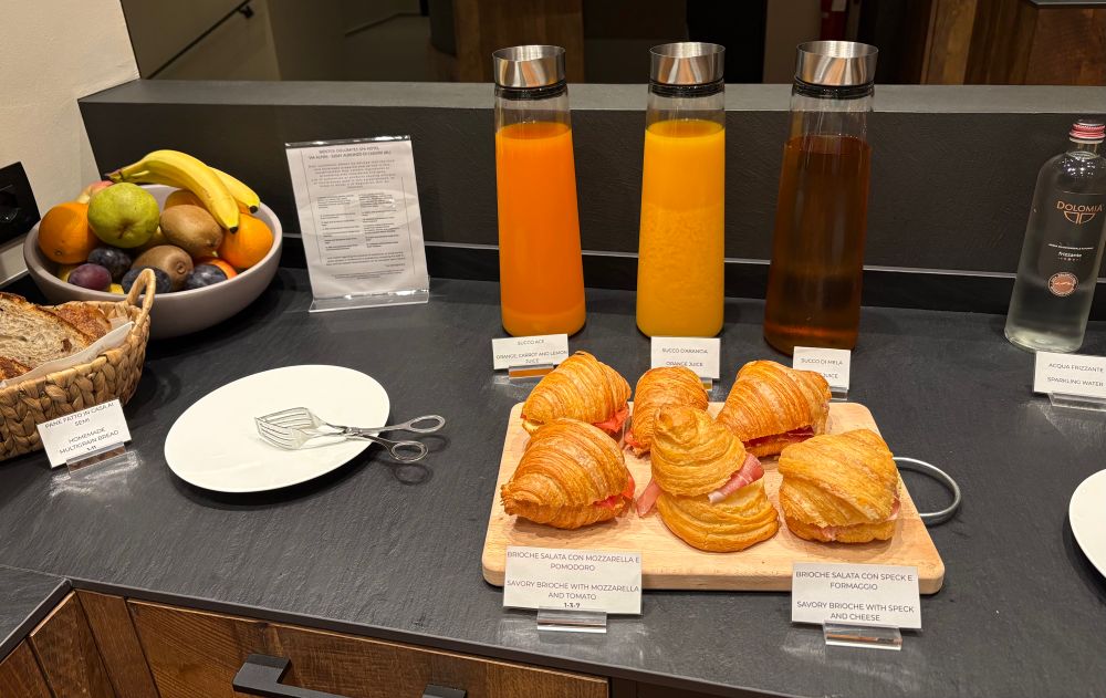 Säfte im Hintergrund, vorne Kipferl mit Speck-Käse und andere mit Tomate-Mozzarella gefüllt 