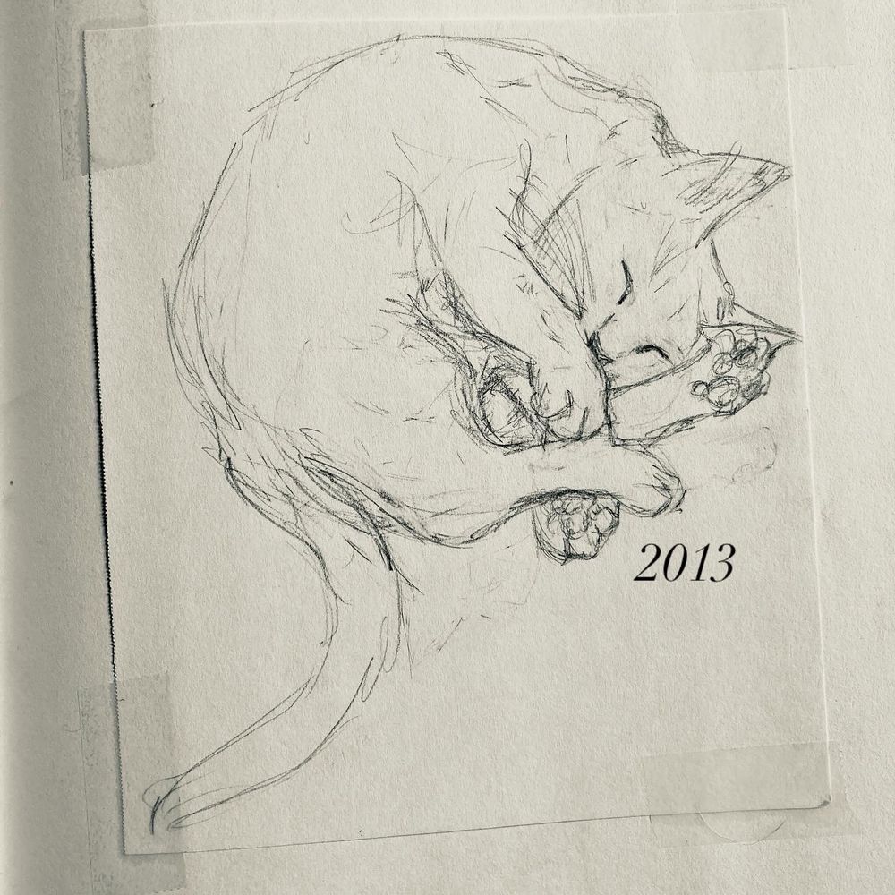 A photo of an old piece of paper taped into a sketchbook. The paper has a rough sketch of a (slightly anatomically incorrect) sleeping cat curled into a ball with her paws sticking out. The year “2013” was added digitally in the margin. 