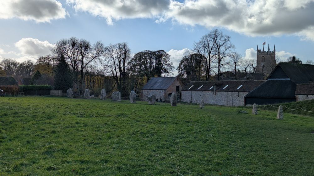 Part of the Neolithic stone circle at Avebury, with the village in the background.