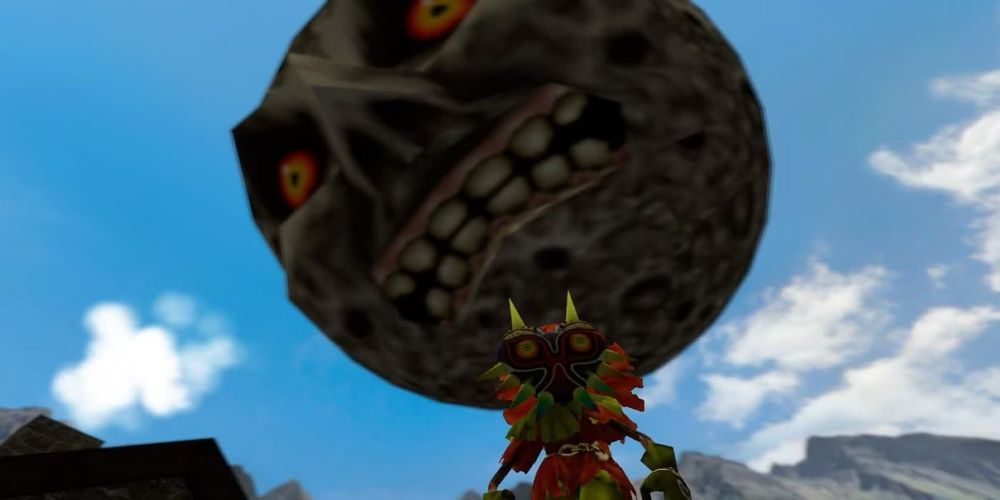 a screenshot of the video game majora’s mask showing a terrifying moon with red and yellow menacing eyes and teeth alarmingly close to the ground