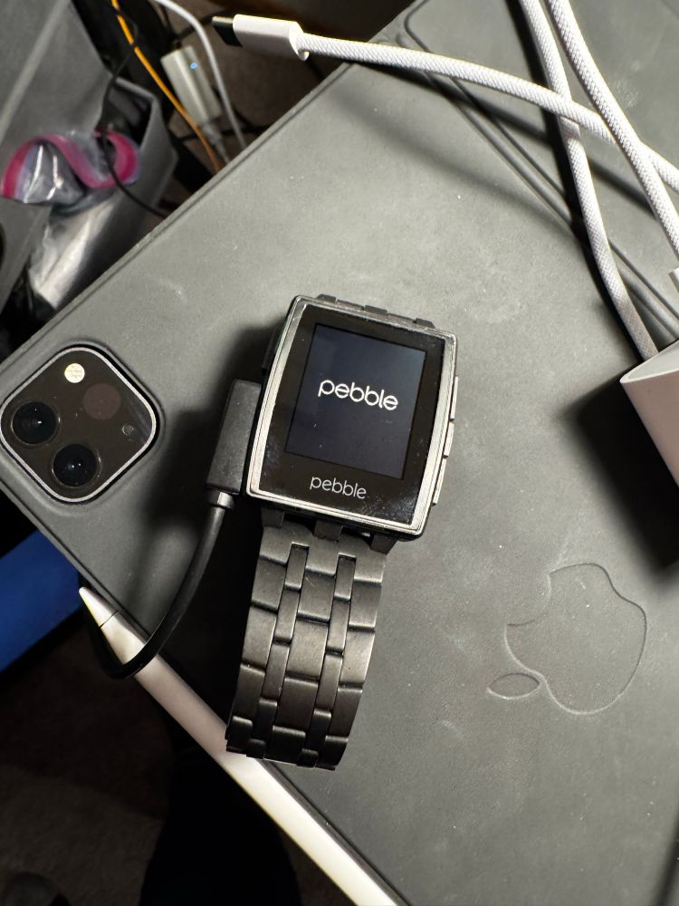 A Pebble Steel charging on a desk 
