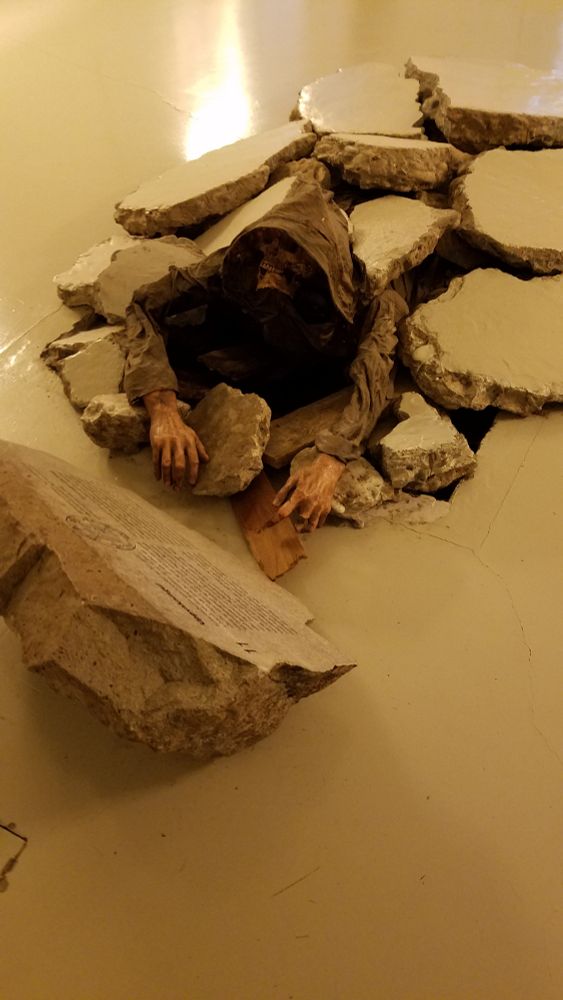 Hooded skeleton climbing through a broken floor
