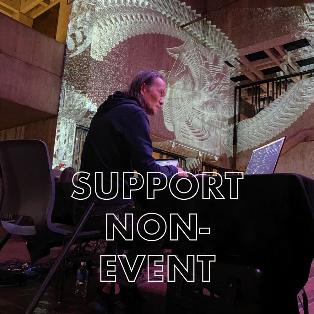 Photo of Feng Jiangzhou performing inside Boston City Hall with a projection onto the concrete walls behind him with the words "Support Non-Event" (Photo: Susanna Bolle)