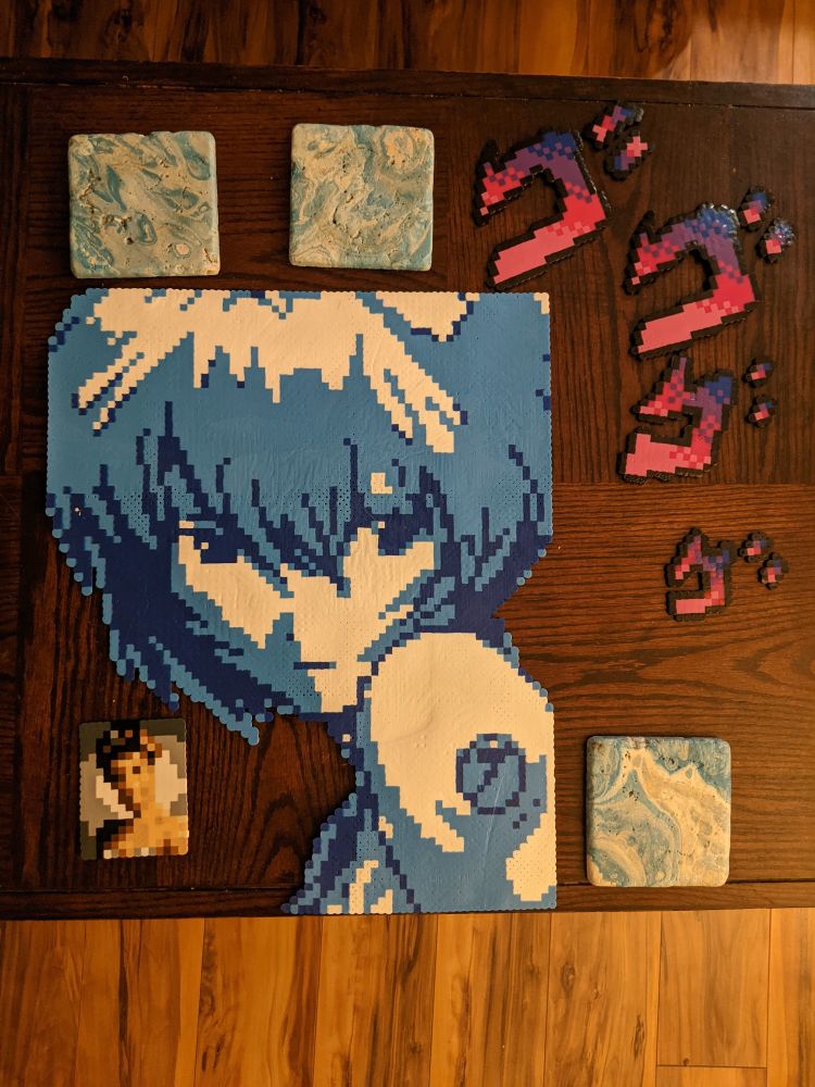 Perler bead models of Rei Ayanami from Neon Genesis Evangelion, the MENACING sound effect from JoJo's Bizarre Adventure and the photo of Laura Palmer from Twin Peaks.