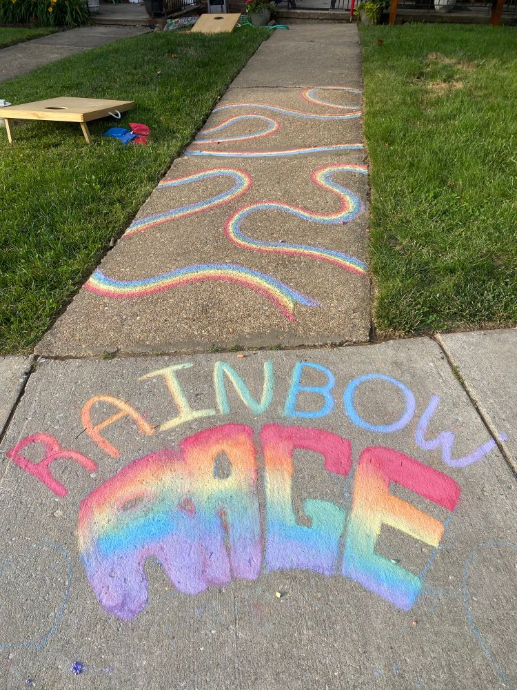 Sidewalk with “rainbow rage” written in rainbow colors in chalk