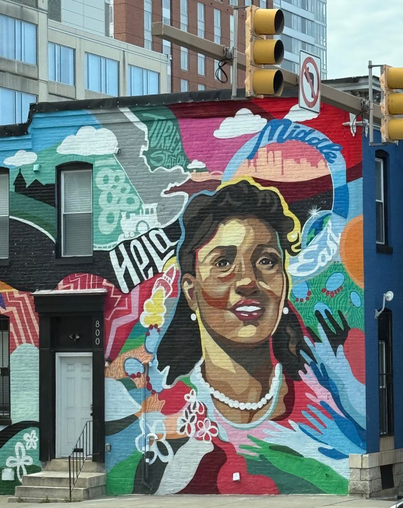 Colorful mural painted on the side of a building with the likeness of Henrietta Lacks and the words “HeLa” and “Middle East” on it.  