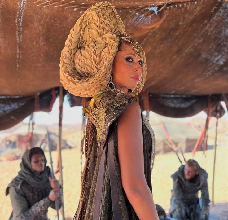 Rainha tribal aiel com trajes marrom,com adereço de cabeça bege de pano trançado 