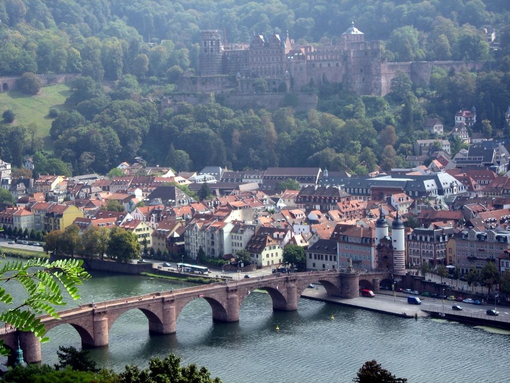 A photo of the Heidelberg, Germany, old city toward the Heidelberger Schloss overlooking the Alte Brücke and Neckar River, taken from the Philosophenweg.